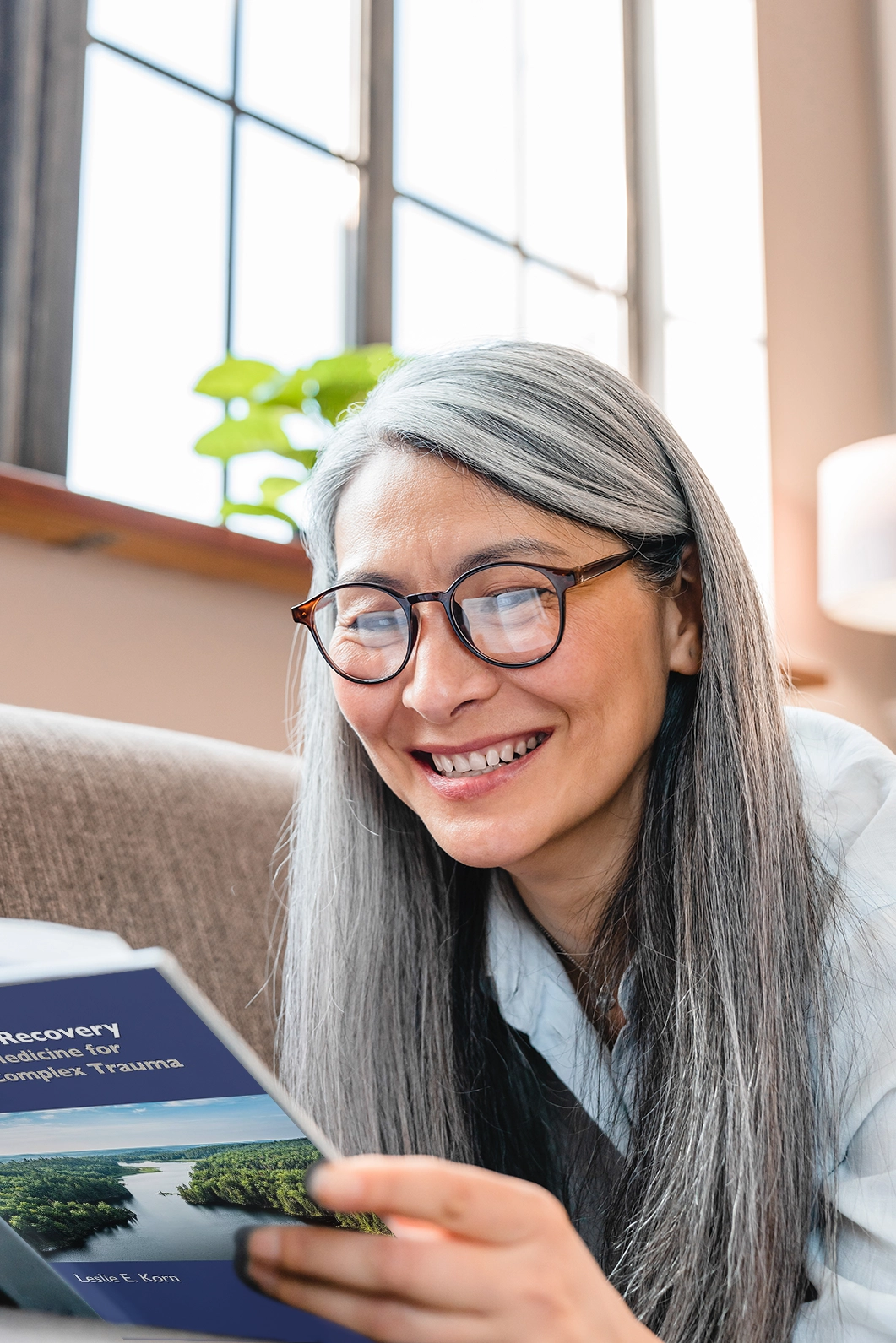 Woman smiles while reading Rhythms of Recovery